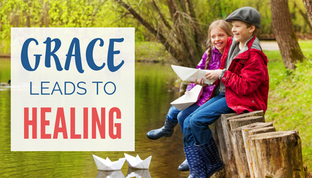 Children laughing making paper boats at lake