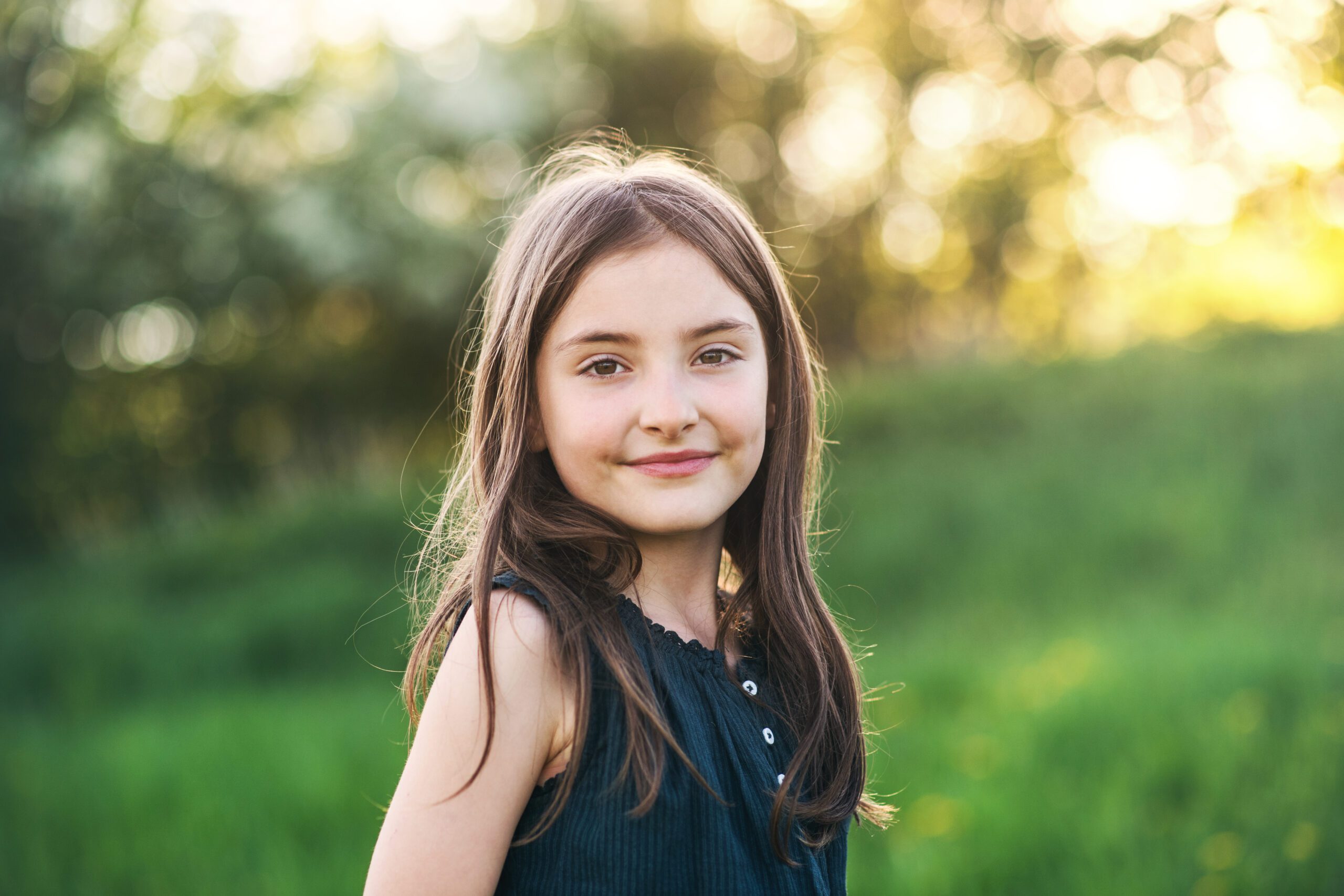 A small girl standing outside in nature.