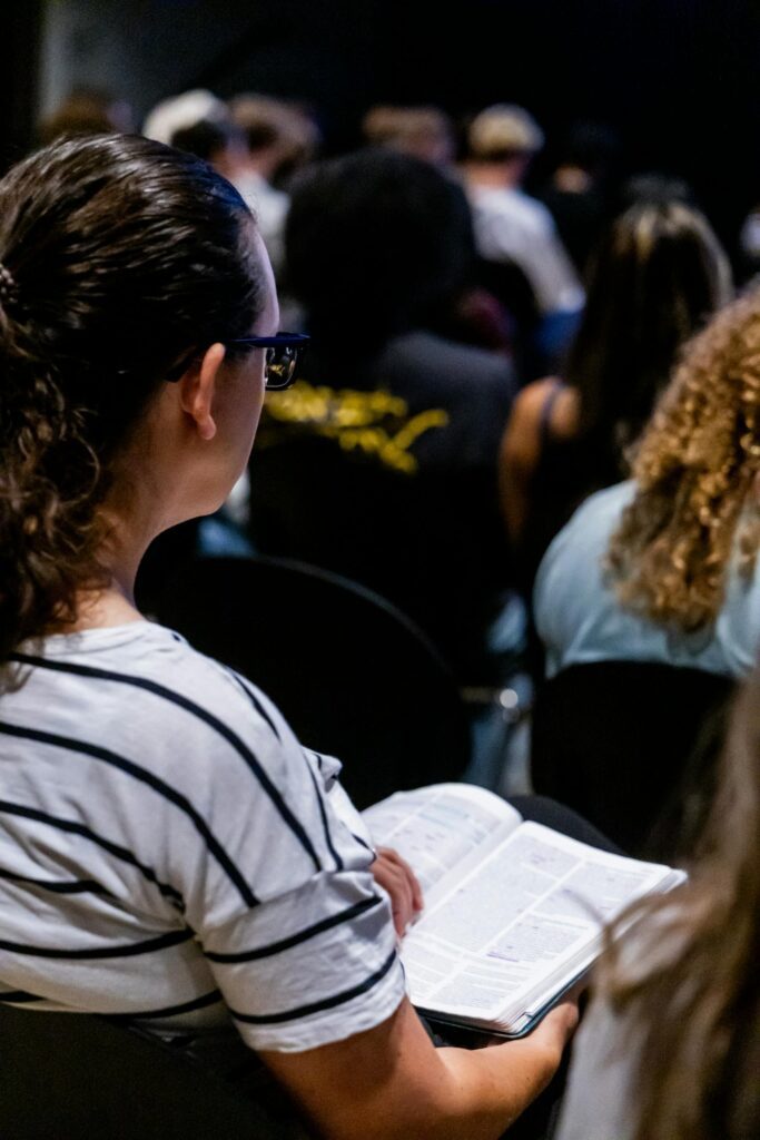 Adult woman attentively reading in a classroom setting during a seminar.