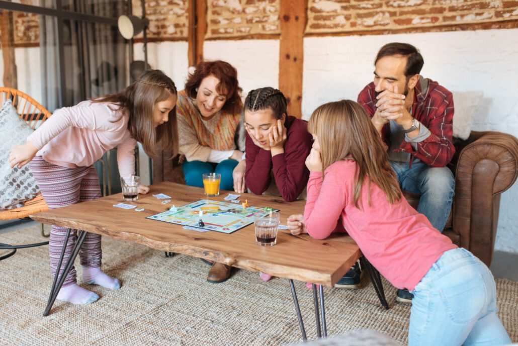 Happy family at home in the couch playing classic table games