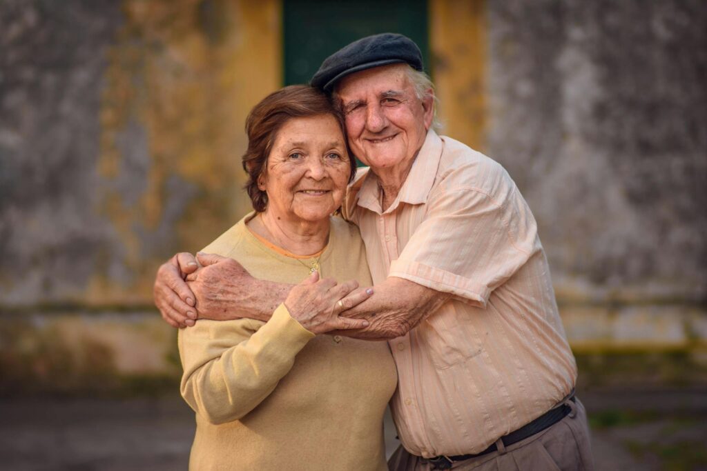 Heartwarming image of an elderly couple embracing outdoors, embodying love and companionship.