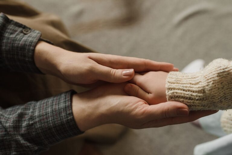 An adult holds a child's hand, illustrating out-of-home care in the North Carolina foster care system