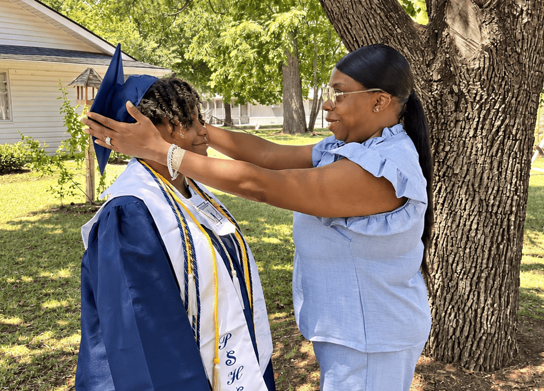 Denise Lewis helps Autumn with her graduation cap.