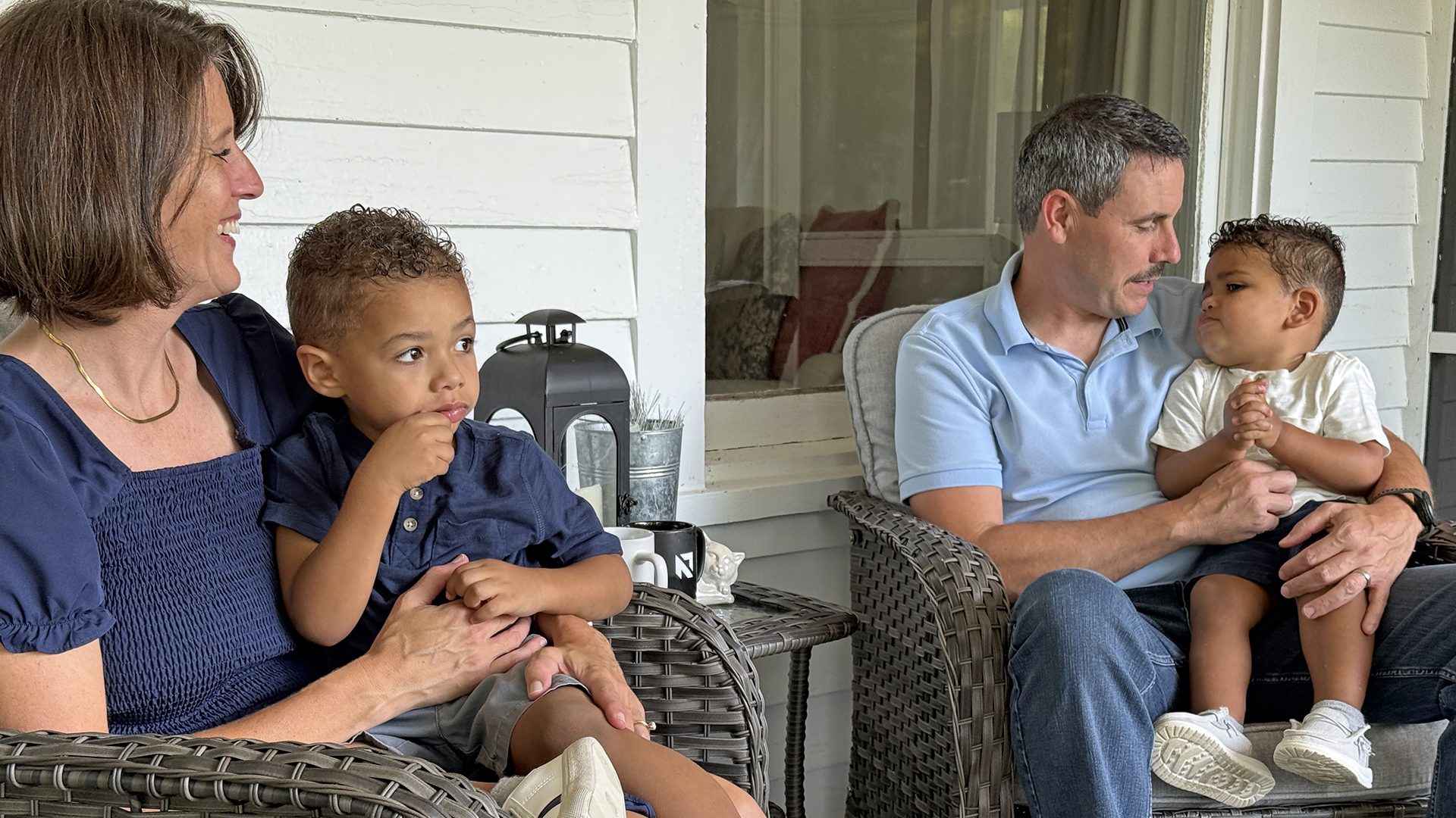 Kelly and Bradley Johnson on their porch with their two boys